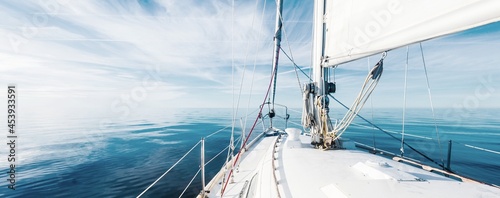Fotografia White sloop rigged yacht sailing in an open Baltic sea on a clear sunny day