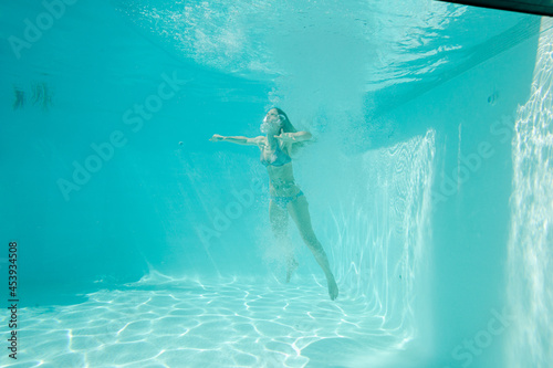 Woman swimming underwater in pool