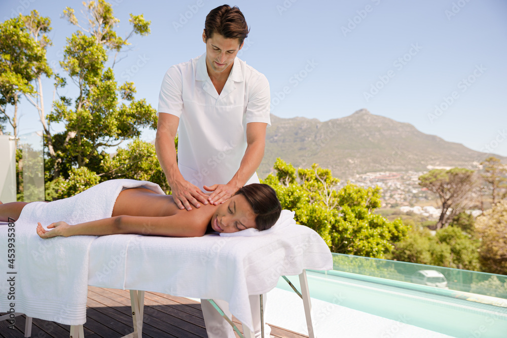 Woman receiving massage poolside at spa Woman receiving massage poolside at spa
