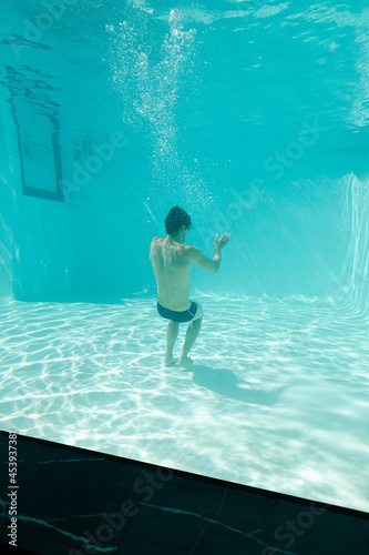 Man posing underwater in swimming pool