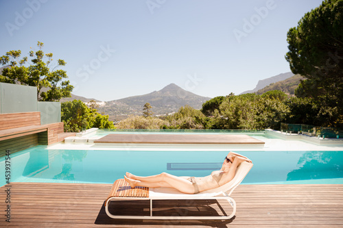 Fotografija Woman sunbathing at poolside