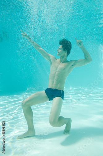 Man posing underwater in swimming pool