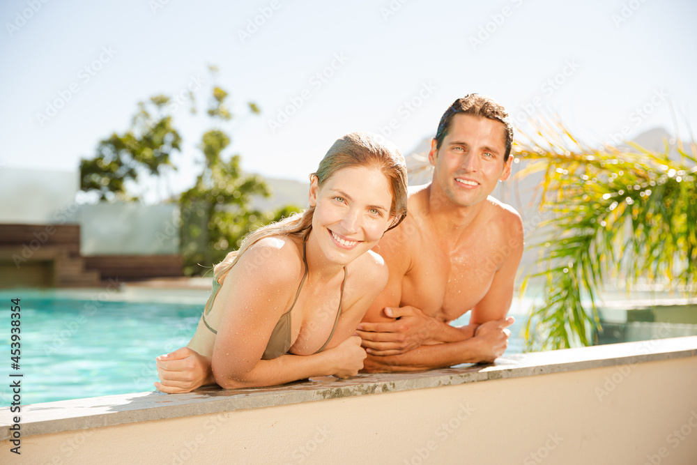 Portrait of smiling couple relaxing in swimming pool Portrait of smiling couple relaxing in swimming pool