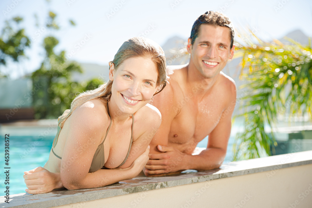 Portrait of smiling couple relaxing in swimming pool Portrait of smiling couple relaxing in swimming pool