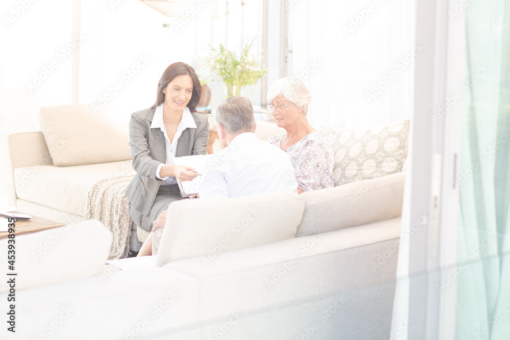 Financial advisor talking to couple on sofa Financial advisor talking to couple on sofa