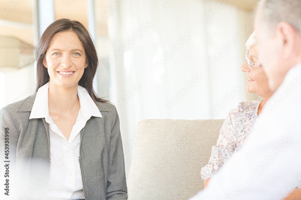 Financial advisor talking to couple on sofa Financial advisor talking to couple on sofa