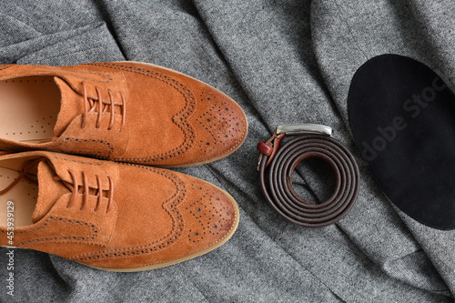A pair of brown suede derby shoes and leather belt on tweed fabric background Poster Mural XXL