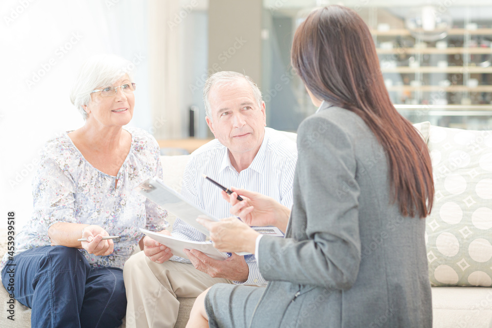 Financial advisor talking to couple on sofa Financial advisor talking to couple on sofa