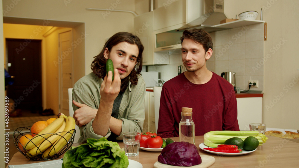 One of friend's is talking about cucumbers and the other is listening One of friend's is talking about cucumbers and the other is listening