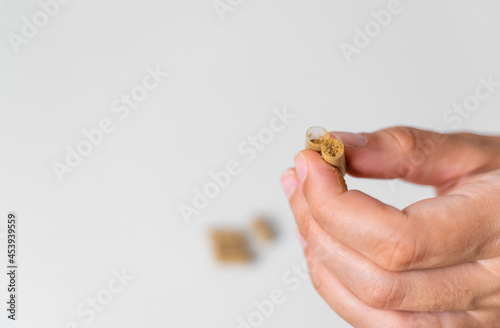 Close up hand with herb capsule on white background. Microdosing concept. Psychedelics therapy. Depression, anxiety treatment  photo