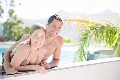 Portrait of smiling couple relaxing in swimming pool