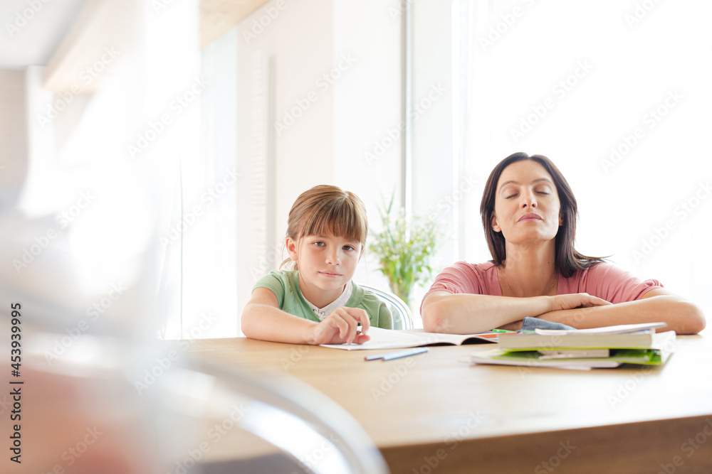 Mother helping daughter with homework Mother helping daughter with homework