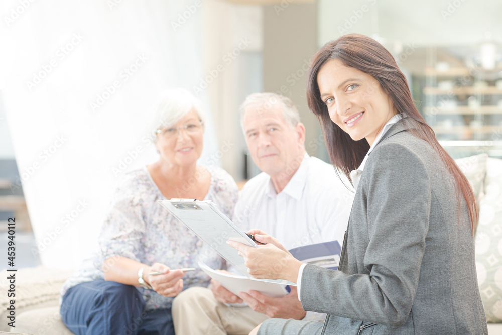 Financial advisor smiling with couple on sofa