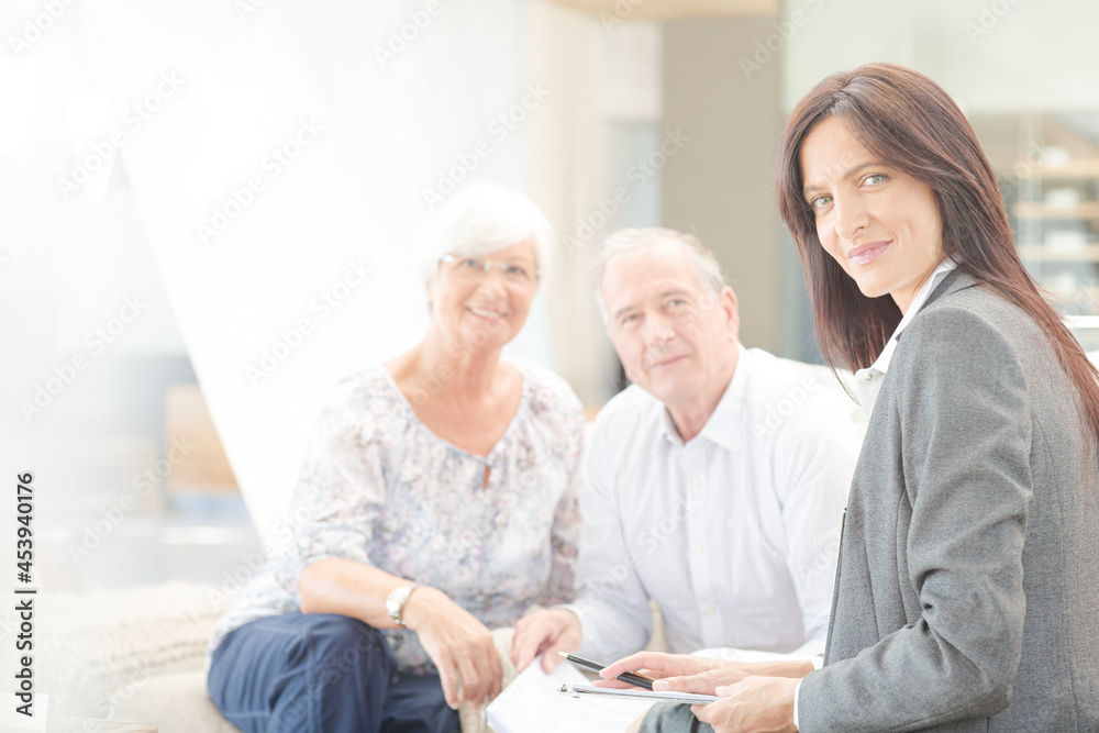 Financial advisor smiling with couple on sofa Financial advisor smiling with couple on sofa