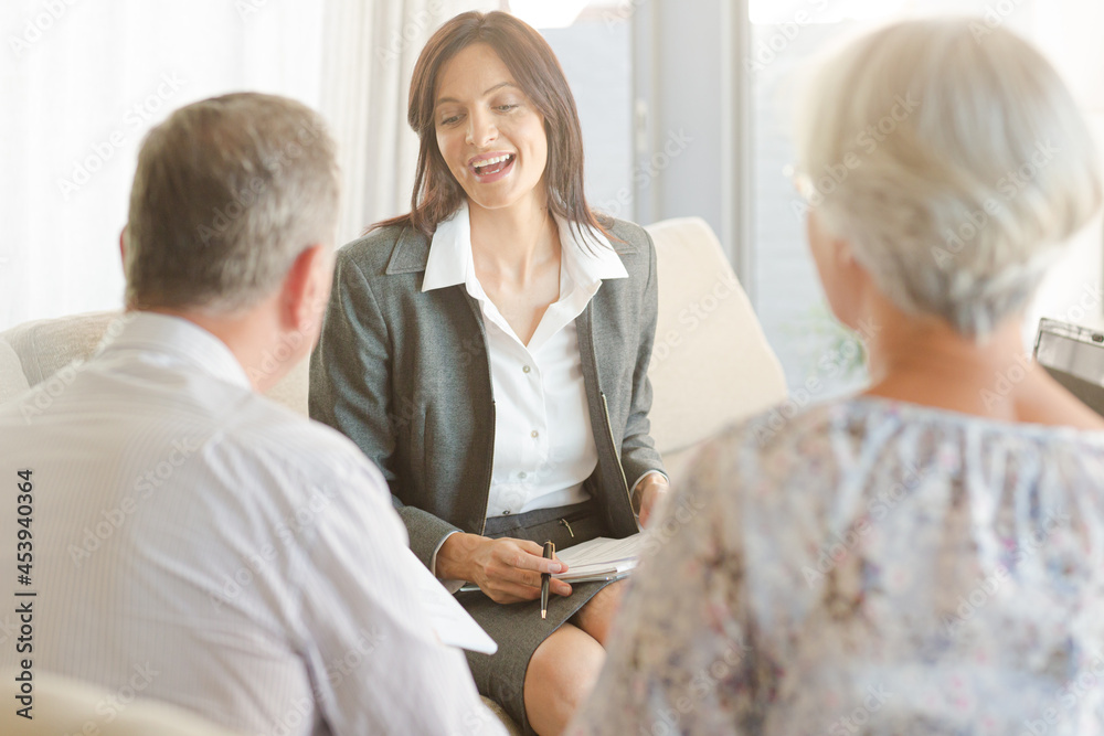 Financial advisor talking to couple on sofa Financial advisor talking to couple on sofa