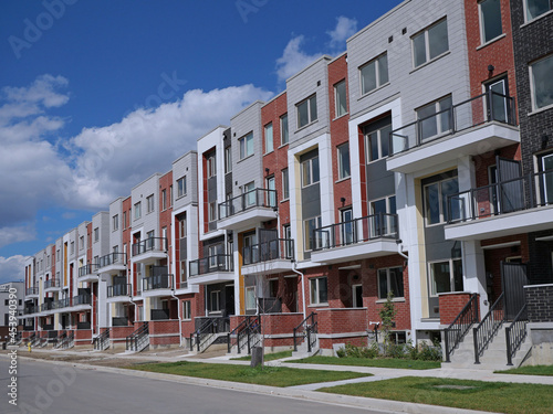 Street with long row of newly built modern brick townhouses