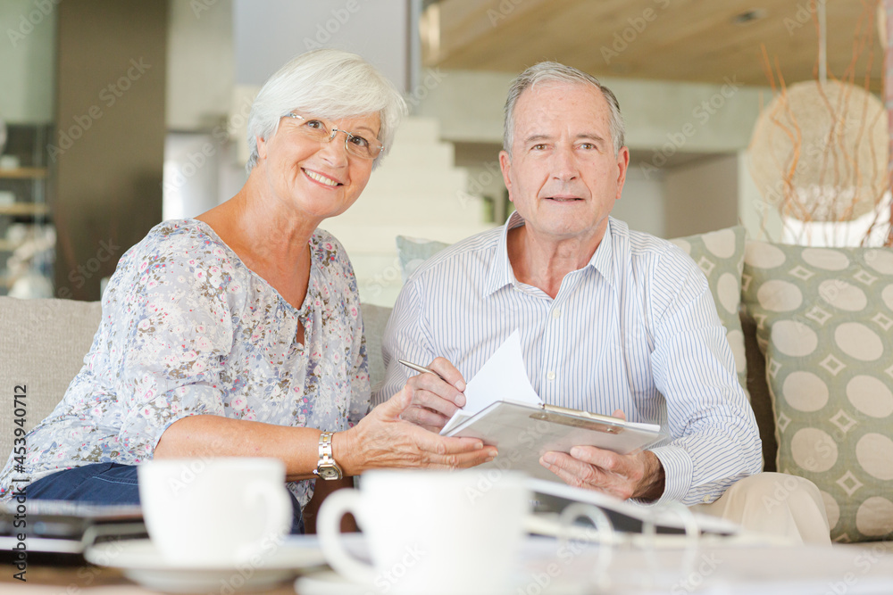 Couple examining blueprints on sofa Couple examining blueprints on sofa