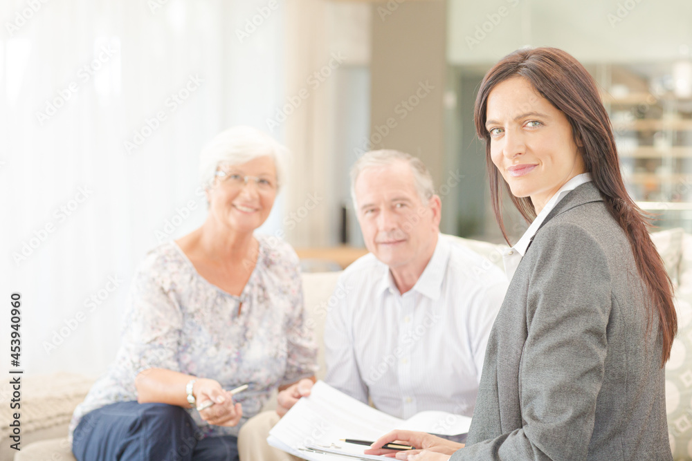 Financial advisor smiling with couple on sofa Financial advisor smiling with couple on sofa