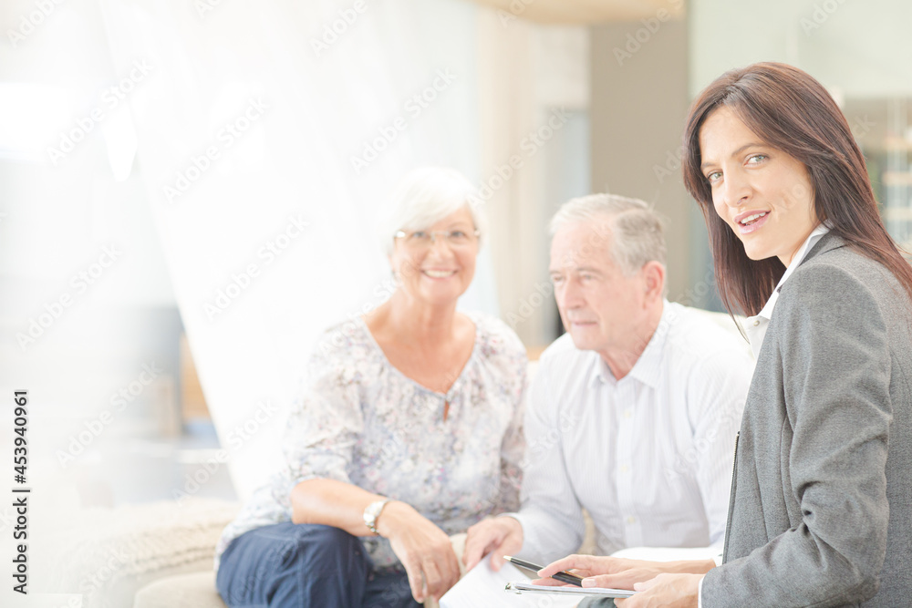 Financial advisor smiling with couple on sofa Financial advisor smiling with couple on sofa