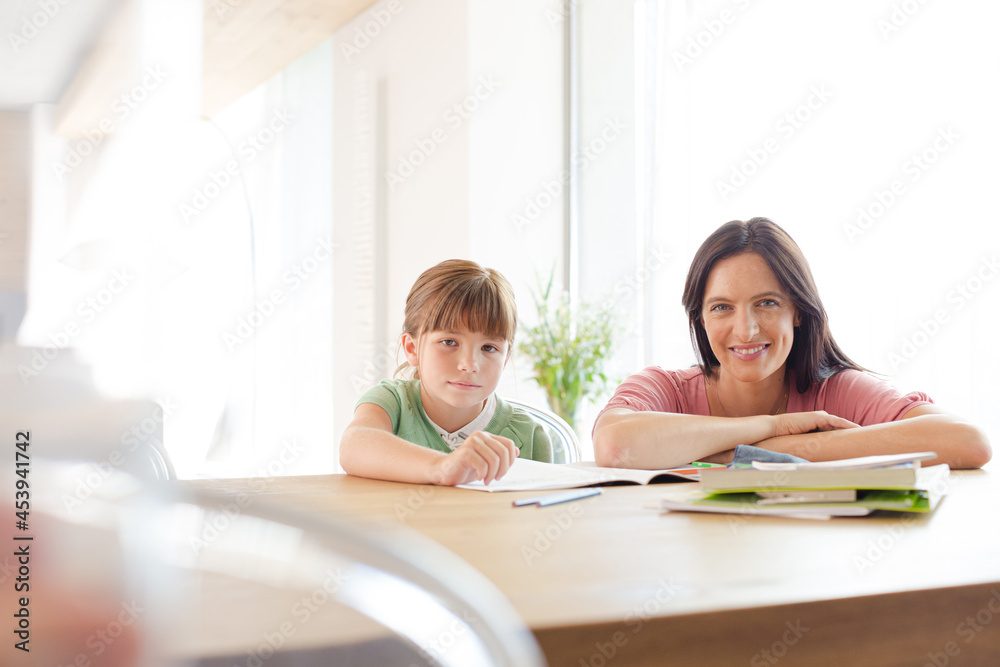 Mother helping daughter with homework Mother helping daughter with homework