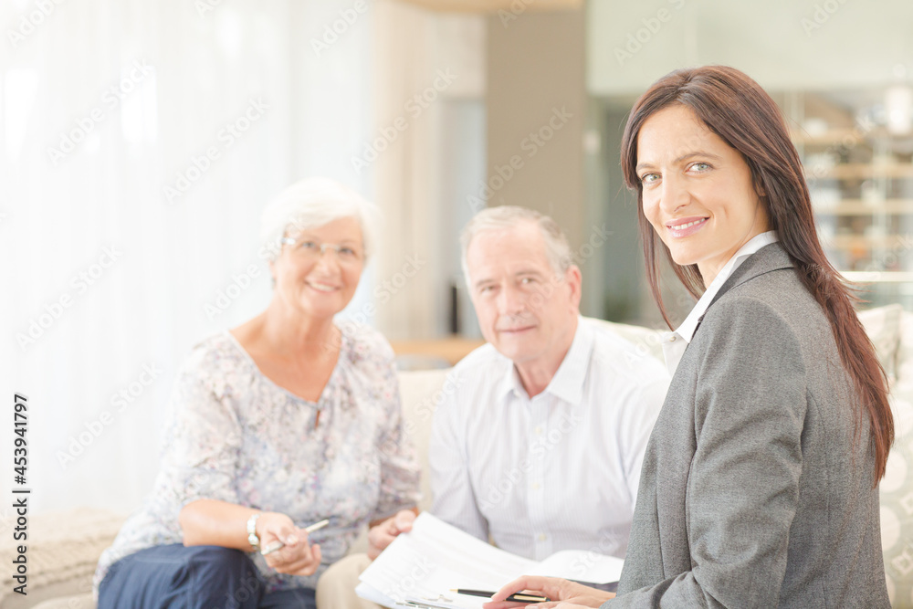 Financial advisor smiling with couple on sofa Financial advisor smiling with couple on sofa