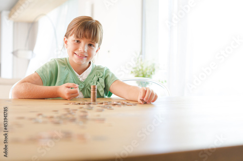 Girl stacking pennies on counter