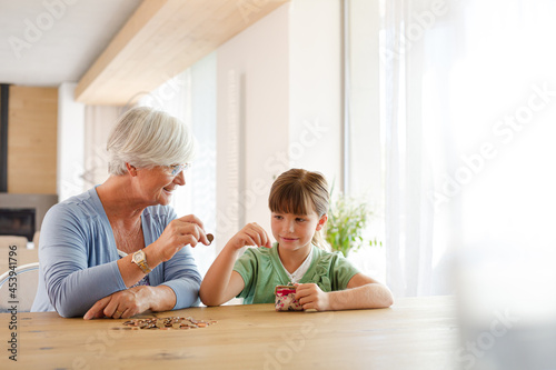 Older woman and granddaughter counting pennies