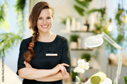 Portrait of happy woman worker in modern beauty salon photo
