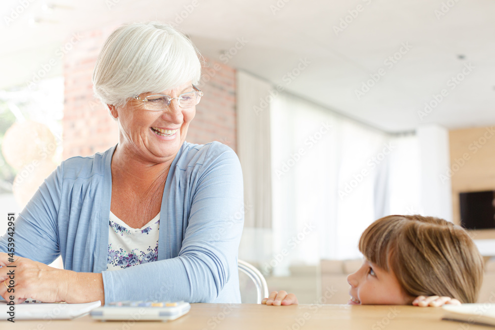 Older woman and granddaughter using calculator Older woman and granddaughter using calculator