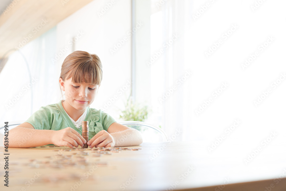 Girl stacking pennies on counter Girl stacking pennies on counter