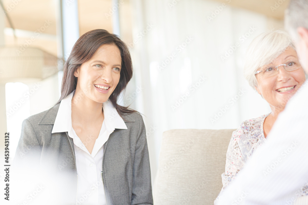Financial advisor talking to couple on sofa Financial advisor talking to couple on sofa