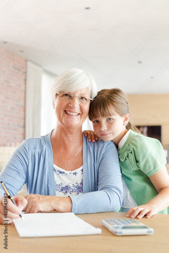 Older woman and granddaughter using calculator Older woman and granddaughter using calculator
