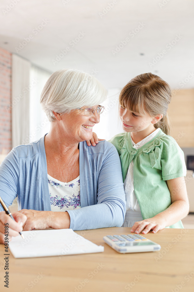 Older woman and granddaughter using calculator Older woman and granddaughter using calculator