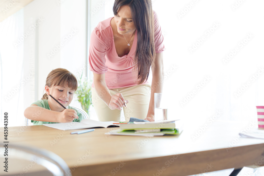 Mother helping daughter with homework Mother helping daughter with homework