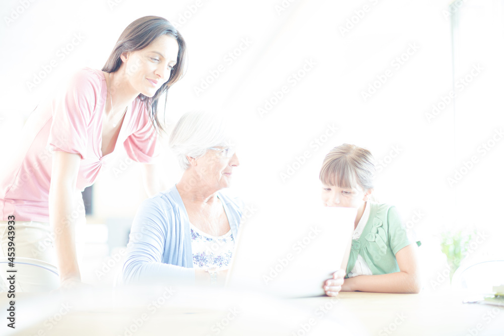 Three generations of women using tablet computer Three generations of women using tablet computer