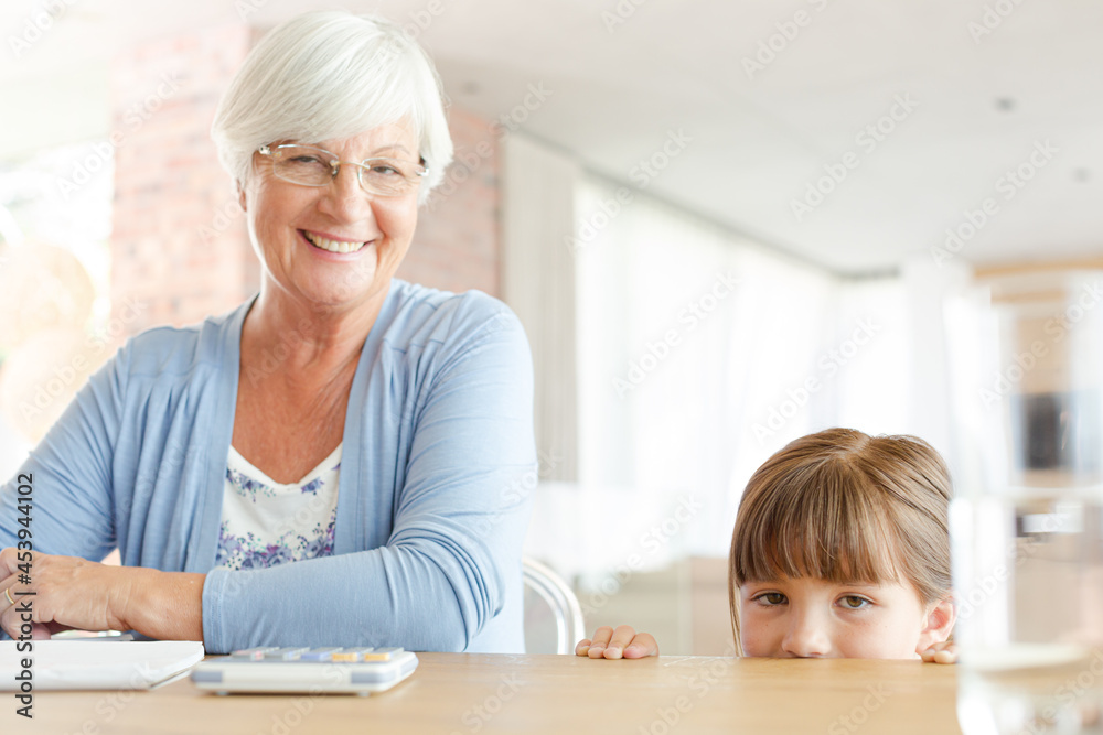 Older woman and granddaughter using calculator Older woman and granddaughter using calculator