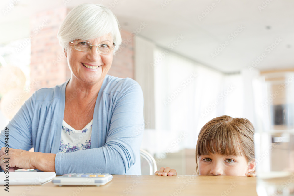 Older woman and granddaughter using calculator Older woman and granddaughter using calculator