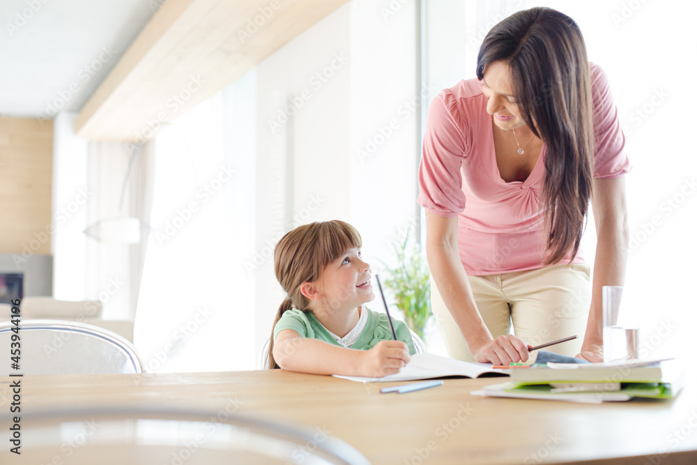 Mother helping daughter with homework Mother helping daughter with homework