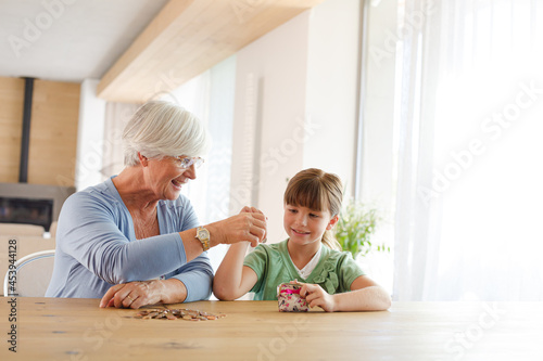 Older woman and granddaughter counting pennies