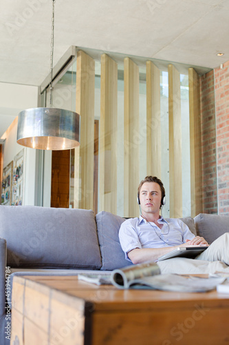 Man using headphones on sofa