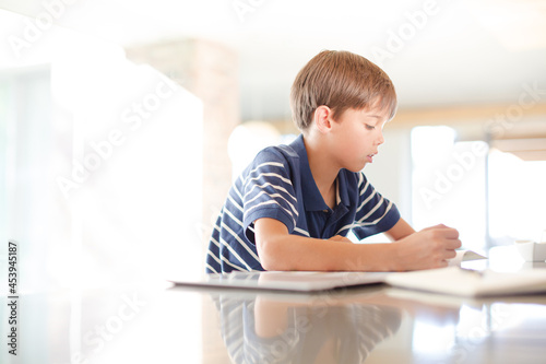 Boy using tablet computer in kitchen