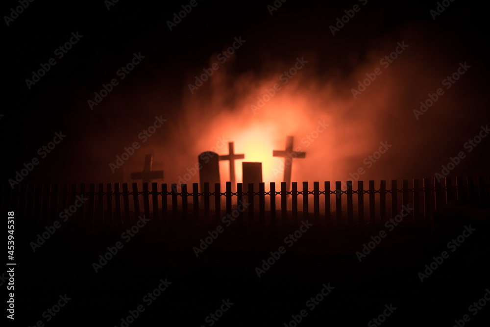 Scary view of zombies at cemetery dead tree, moon, church and spooky cloudy sky with fog, Horror Halloween concept with glowing pumpkin. Selective focus