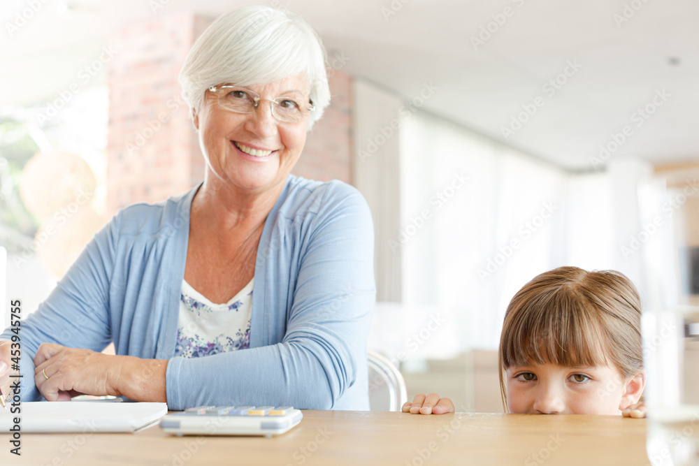 Older woman and granddaughter using calculator Older woman and granddaughter using calculator
