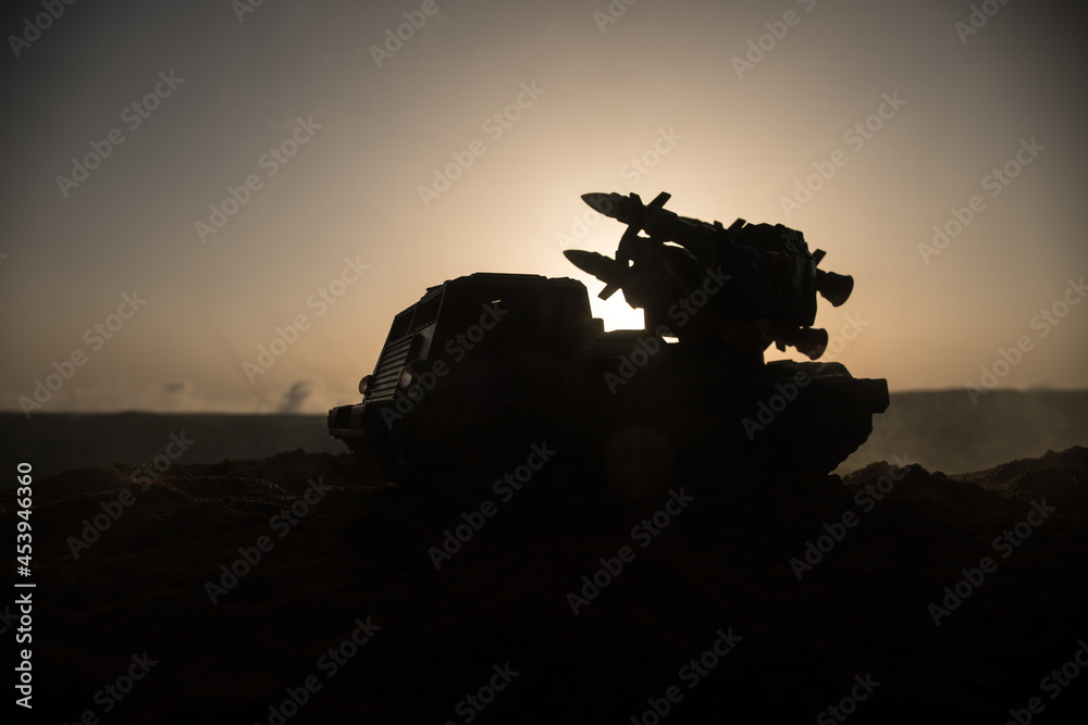 War concept. Battle scene with rocket launcher aimed at gloomy sky at sunset time. Rocket vehicle ready to attacSelective focus