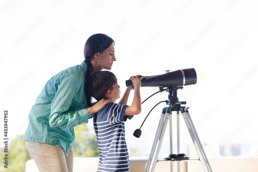 Mother and son using telescope