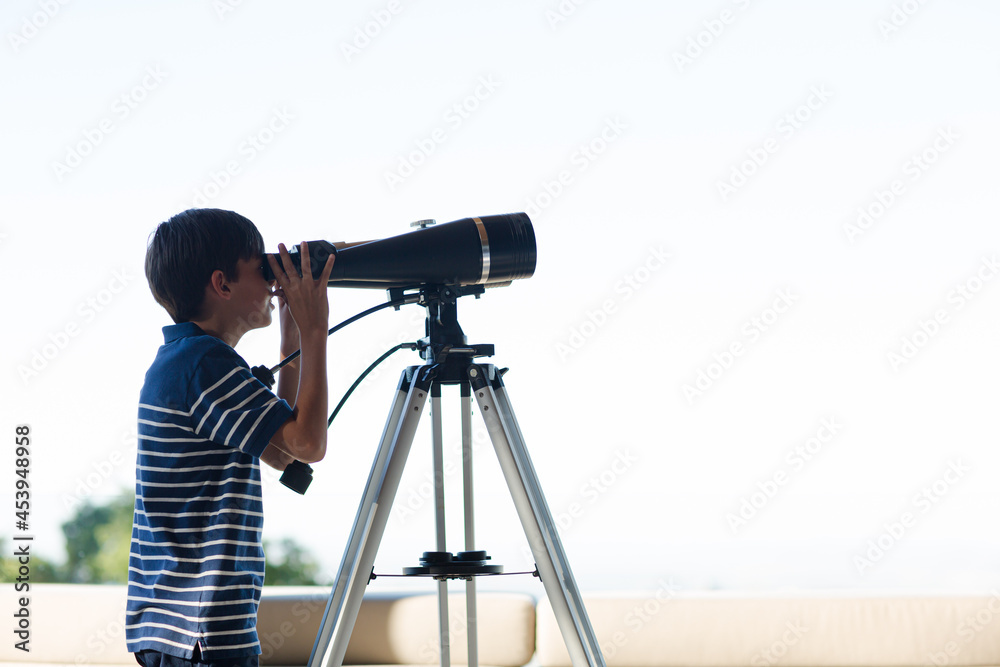 Boy using telescope outdoors Boy using telescope outdoors