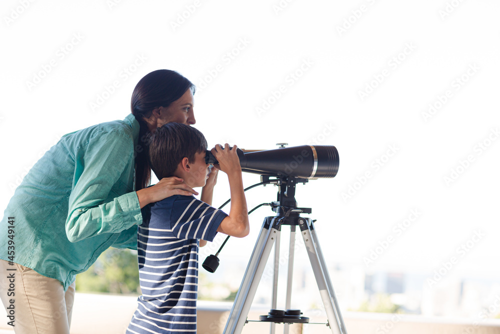 Mother and son using telescope