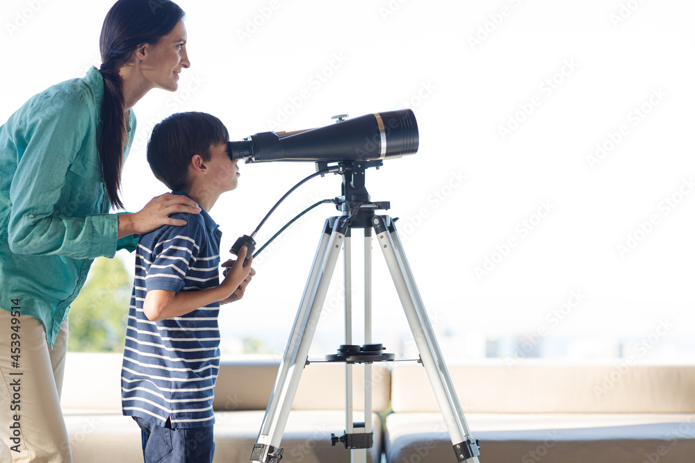 Mother and son using telescope outdoors