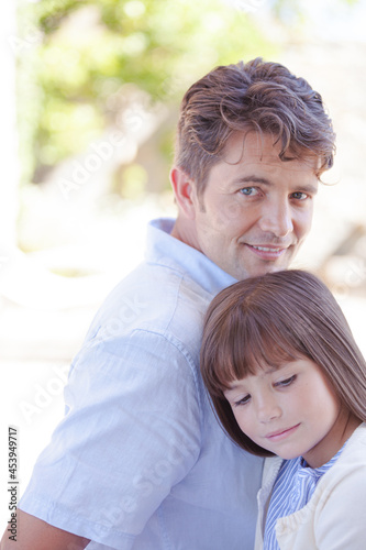 Father and daughter smiling outdoors