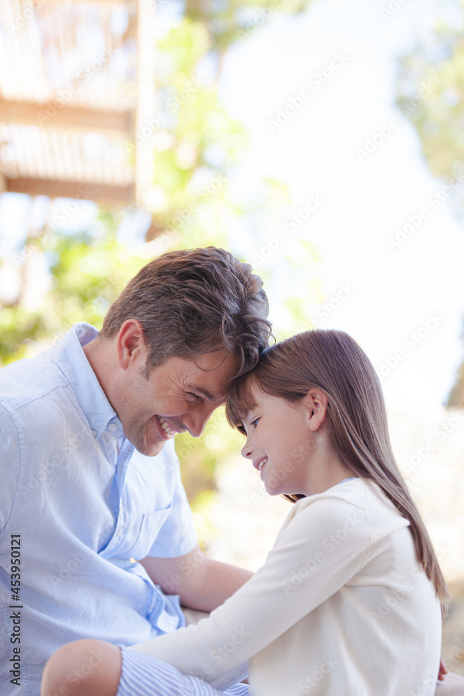 Father and daughter touching foreheads outdoors Father and daughter touching foreheads outdoors